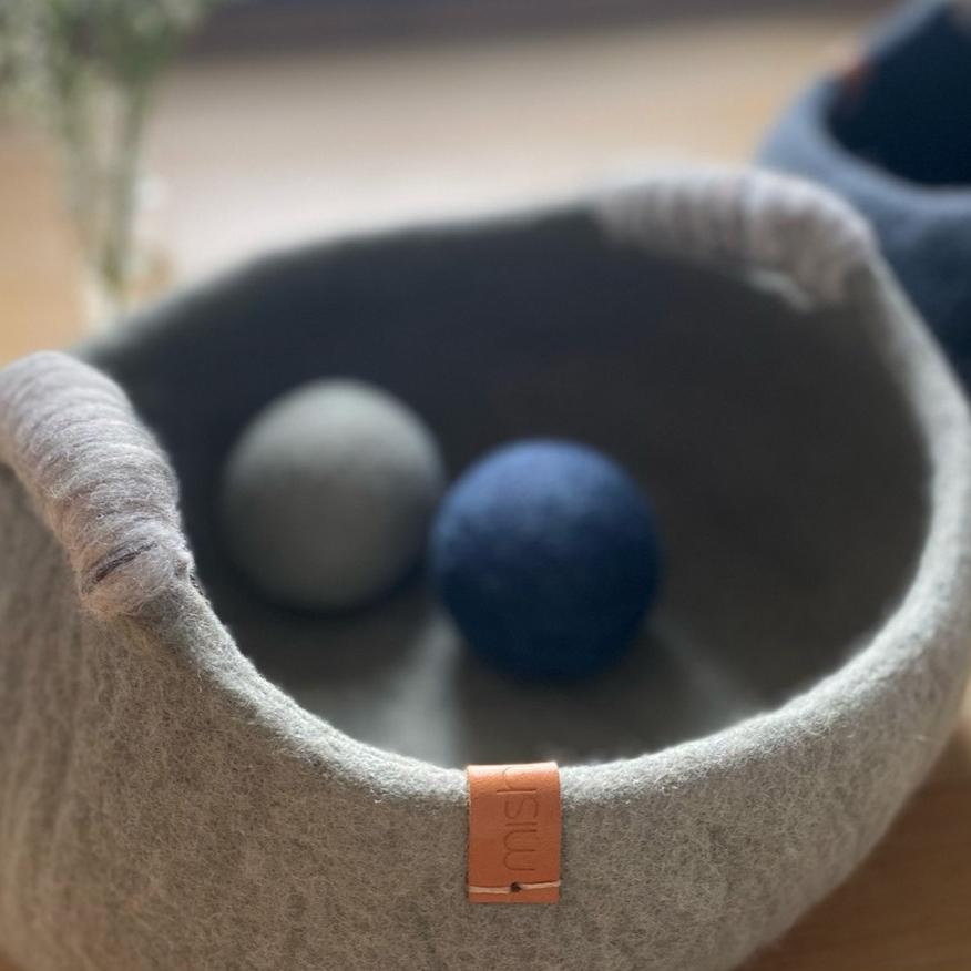 Rassebaelle aus Filz praesentiert in einem Filzkorb blau und gruen